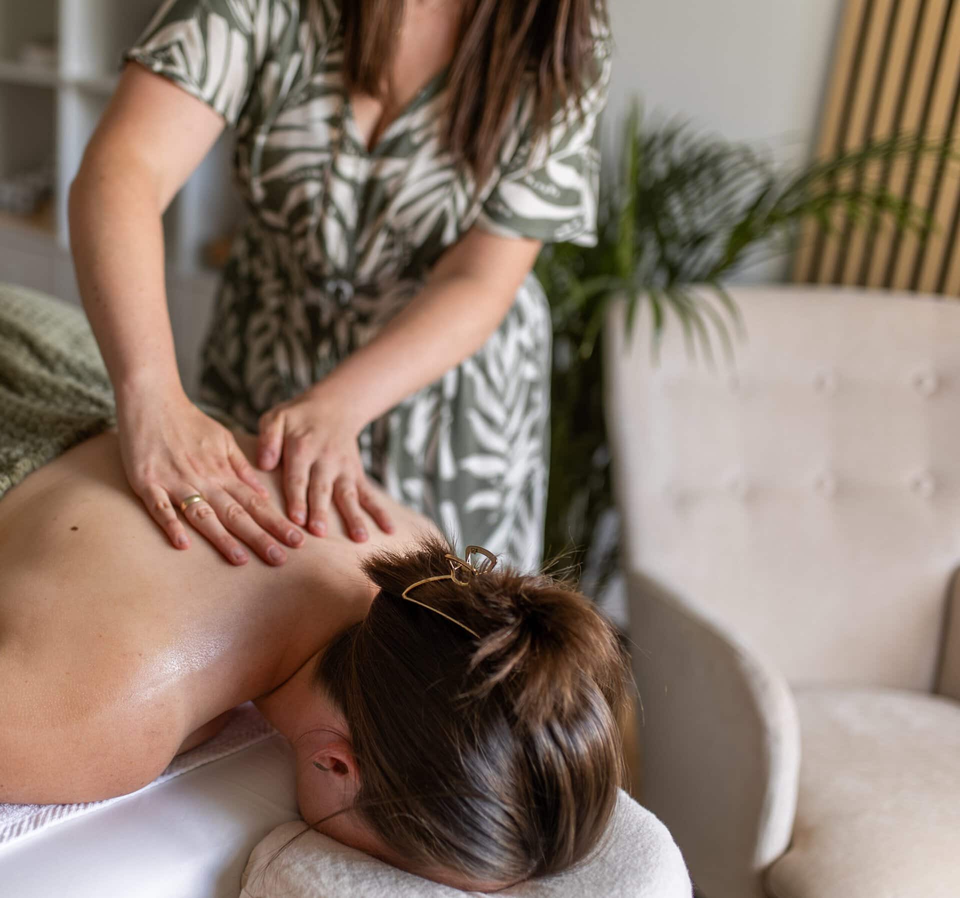 Massage bei einer Frau in entspannter Atmosphäre.