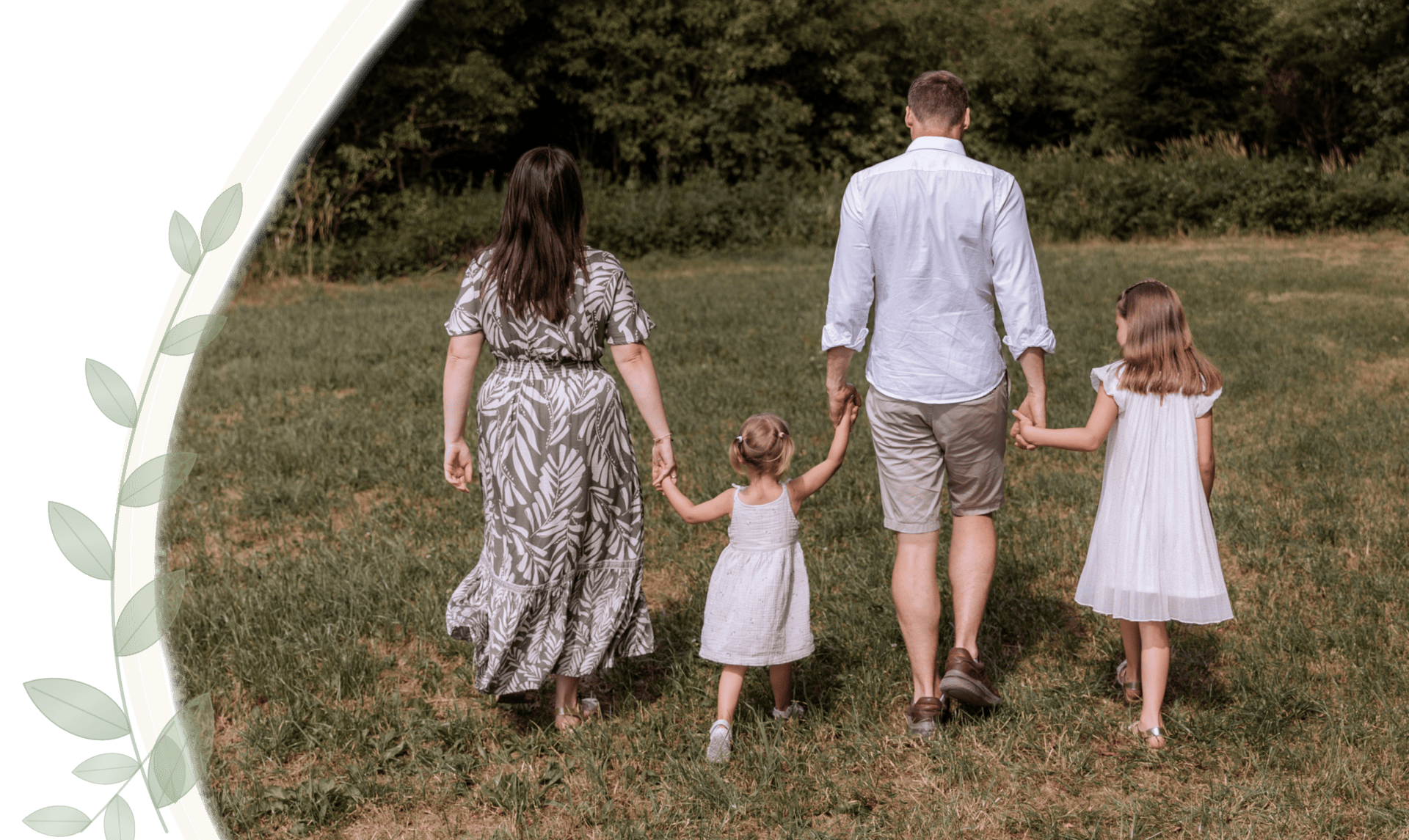 Familie beim Spaziergang im Grünen, Kinder und Eltern Hand in Hand.