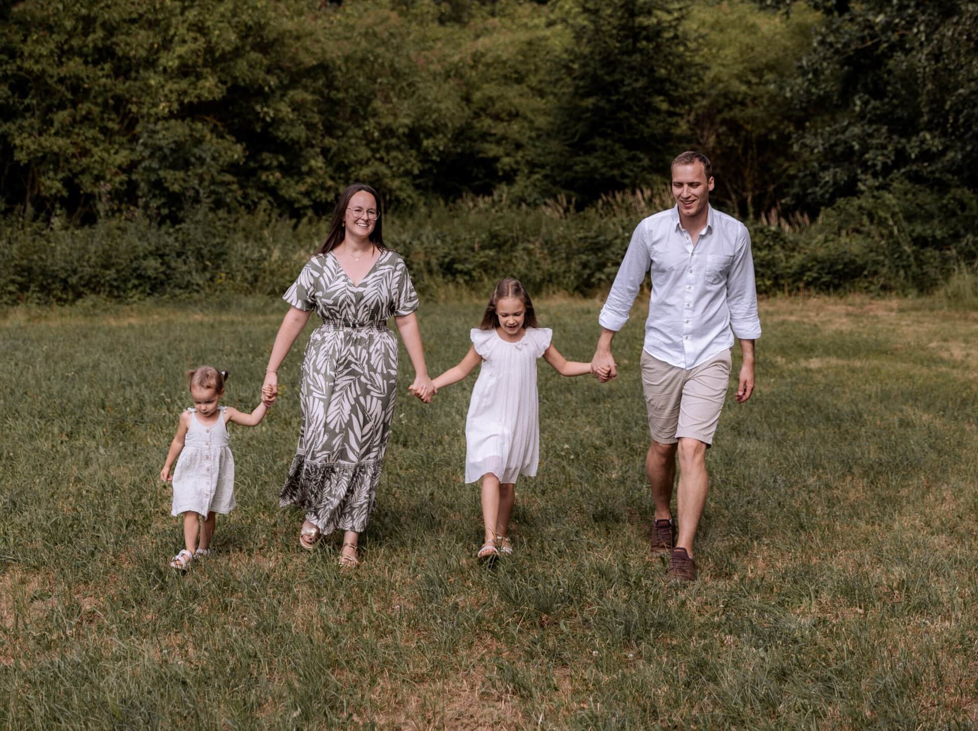 Familie beim Spaziergang im Grünen, Eltern mit Kindern in Natur.
